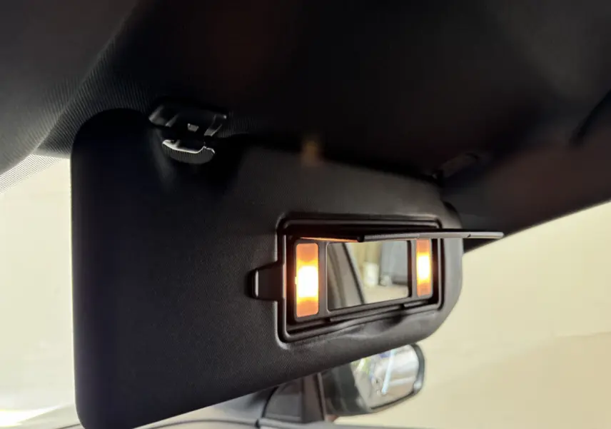 Détail du pare-soleil côté conducteur avec miroir éclairé dans l'habitacle d'un Peugeot 3008 gris clair 2021.