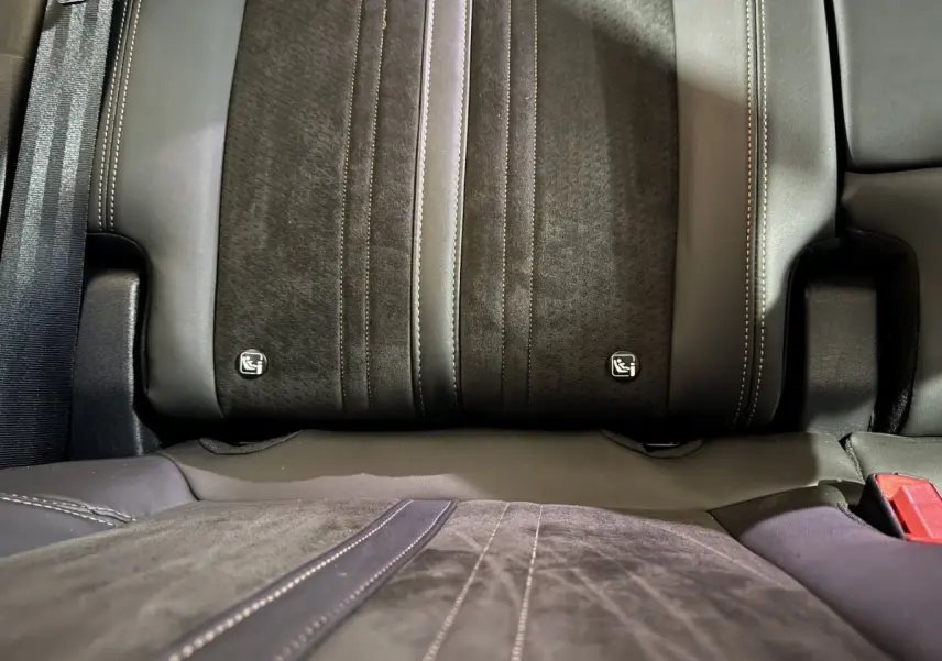 Gros plan sur la banquette arrière en cuir et alcantara gris foncé du Peugeot 3008, avec logos Isofix visibles.