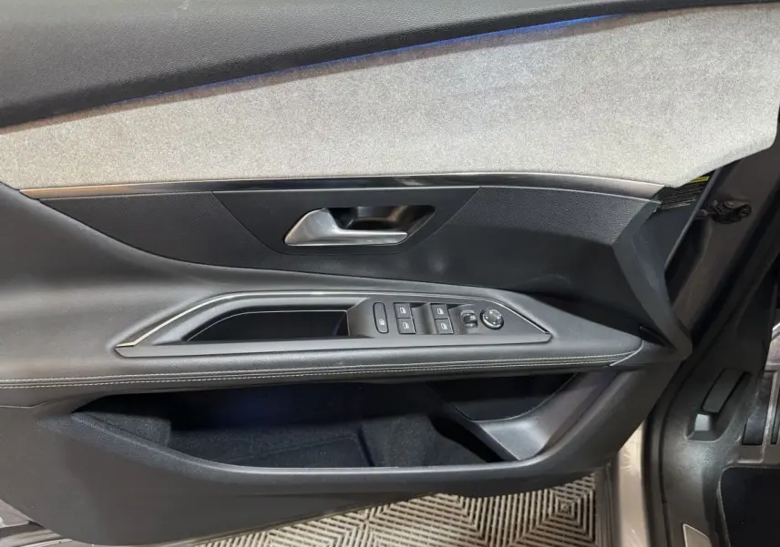 Vue intérieure côté conducteur de la porte du Peugeot 3008 GT gris clair avec commandes vitres et rétroviseurs.