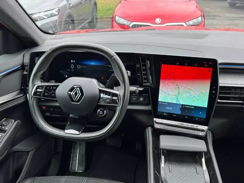 Vue intérieure avant du Renault Austral 2024, volant multifonction et grand écran tactile central avec GPS affiché.