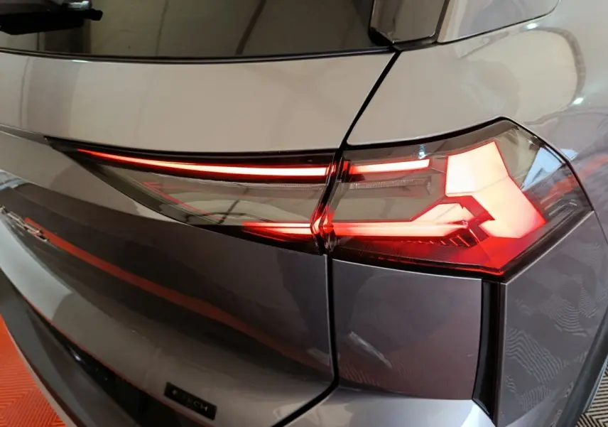 Gros plan sur le feu arrière droit rouge et blanc du Renault SYMBIOZ gris, version iconic E-Tech full hybrid 145.