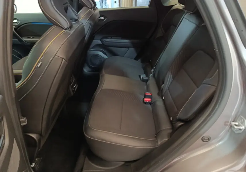 Vue intérieure côté droit sur la banquette arrière noire du Renault SYMBIOZ 2025, avec surpiqûres contrastantes et ceinture rouge.