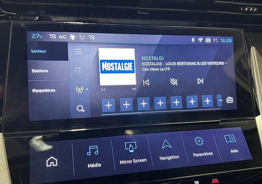 Écran tactile central du Peugeot 308 gris, affichant la radio sur la station Nostalgie avec options multimédia visibles.