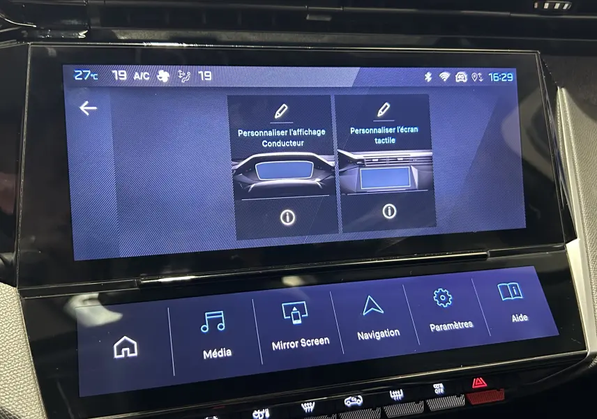 Vue rapprochée de l’écran tactile central de la Peugeot 308 gris, affichant les options de personnalisation et menu multimédia.