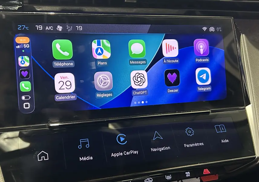Écran tactile central affichant Apple CarPlay dans l’habitacle d’une Peugeot 308 gris, vue de face rapprochée.