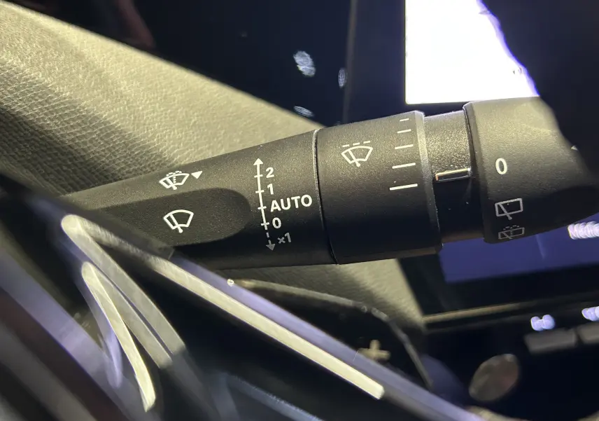 Gros plan sur la commande d’essuie-glace à réglage automatique dans l’habitacle d’une Peugeot 308 gris 2022.