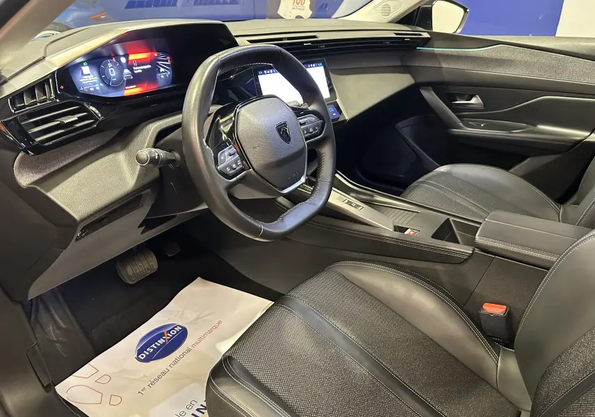 Vue intérieure côté conducteur de la Peugeot 308 gris 2022, avec tableau de bord digital et volant multifonction.