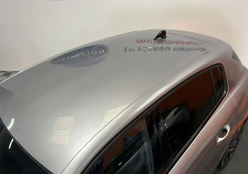 Vue plongeante sur le toit gris métallisé et la partie supérieure des vitres teintées d'une Peugeot 308 5 portes.