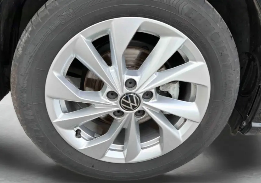 Gros plan sur la jante alliage 16'' Palermo argentée d'une Volkswagen Polo noire, avec logo VW au centre.