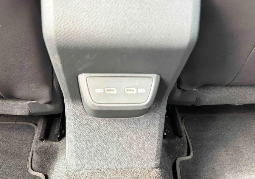 Prise USB-C double vue en gros plan sur la console centrale arrière d’une Volkswagen Polo 2025 noire.