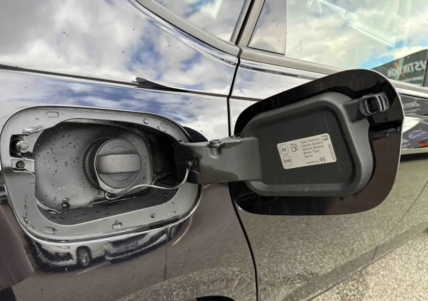 Vue rapprochée de la trappe à carburant ouverte côté gauche d'une Volkswagen Polo noire 2025.