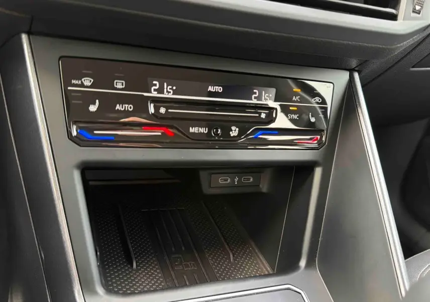 Gros plan sur la console centrale de la Volkswagen Polo noire 2025, montrant la climatisation tactile bi-zone et ports USB-C.