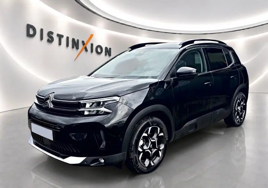 Citroën C5 Aircross noir vue 3/4 avant droit avec jantes alu et barres de toit en showroom.