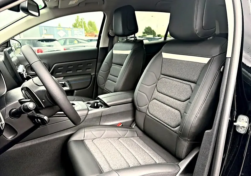 Vue intérieure côté conducteur du Citroën C5 Aircross noir, mettant en valeur les sièges en cuir et tissu gris.