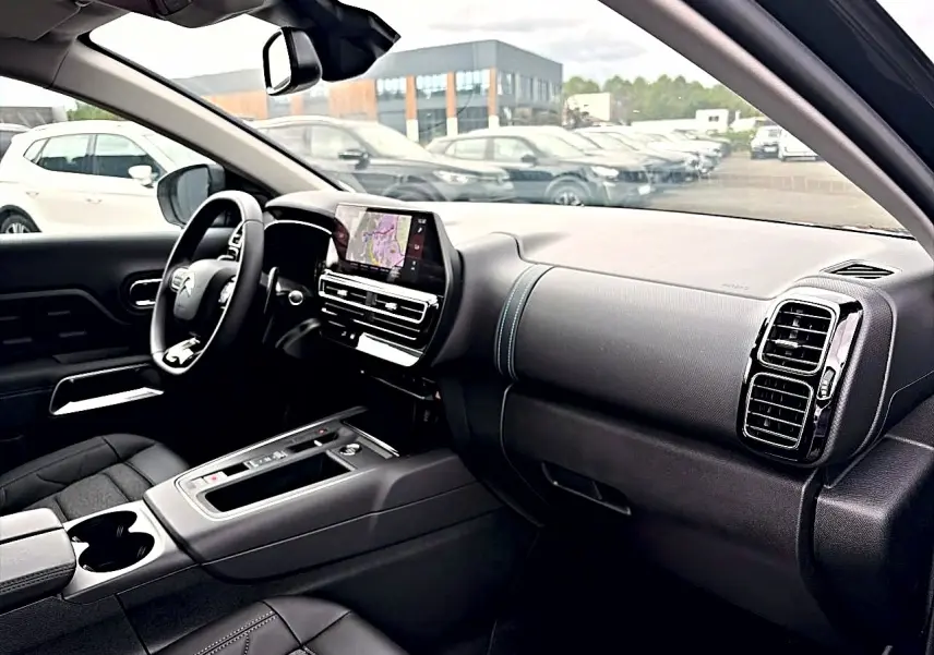 Intérieur noir du Citroën C5 Aircross 2025 vu côté passager, avec écran tactile et volant multifonction.