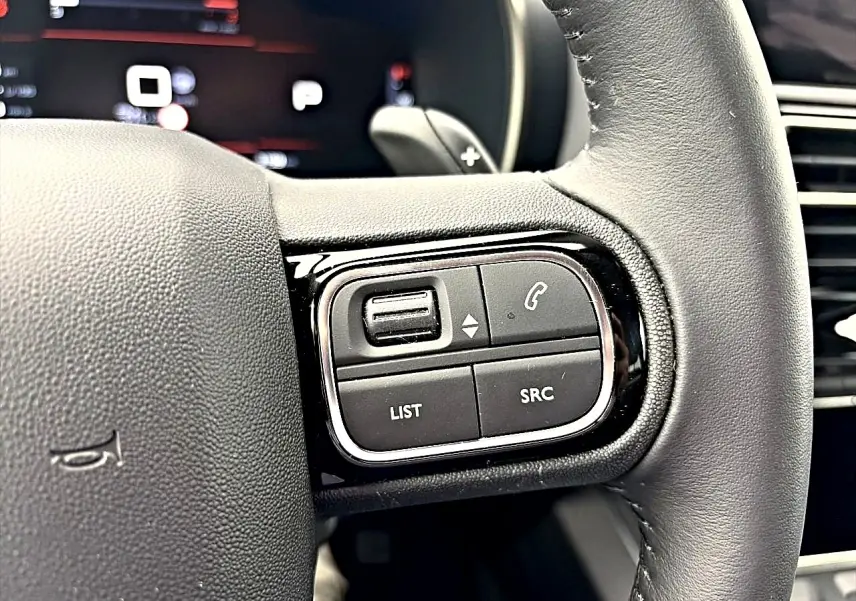 Gros plan sur les commandes multifonctions à droite du volant cuir noir du Citroën C5 Aircross 2025.