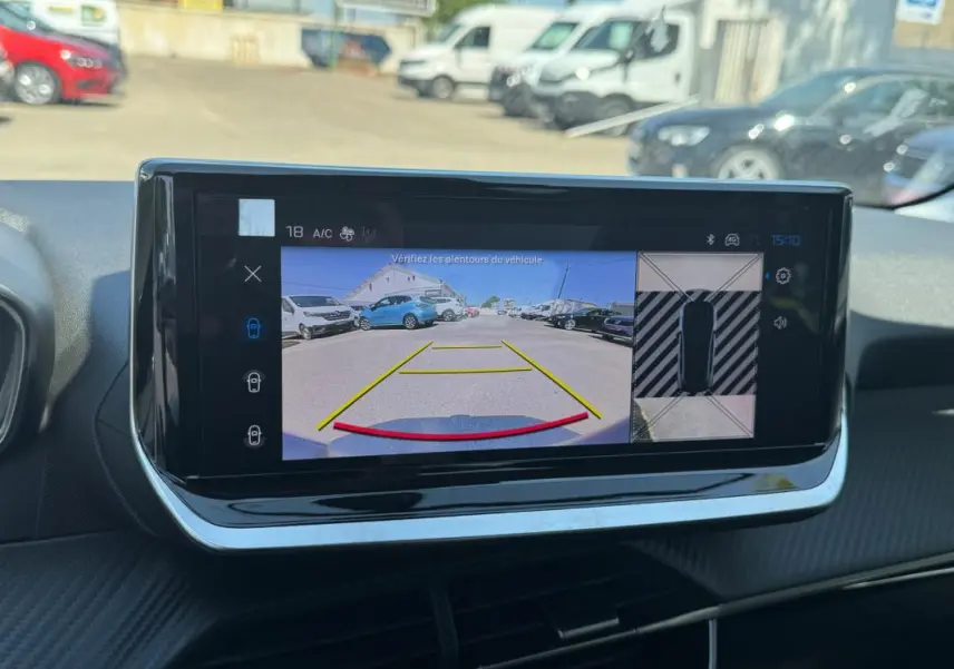 Écran tactile intérieur de la Peugeot 208 Hybrid gris, affichant la caméra de recul avec vue arrière et vue 360° en stationnement.