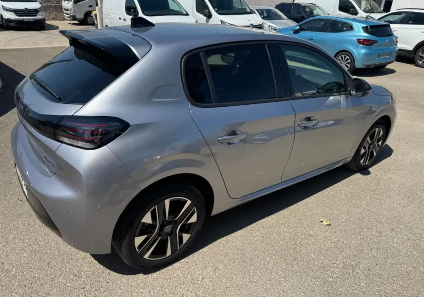 Vue 3/4 arrière droite d'une Peugeot 208 Hybrid 110 gris métallisé avec jantes alliage 16 pouces et antenne requin.