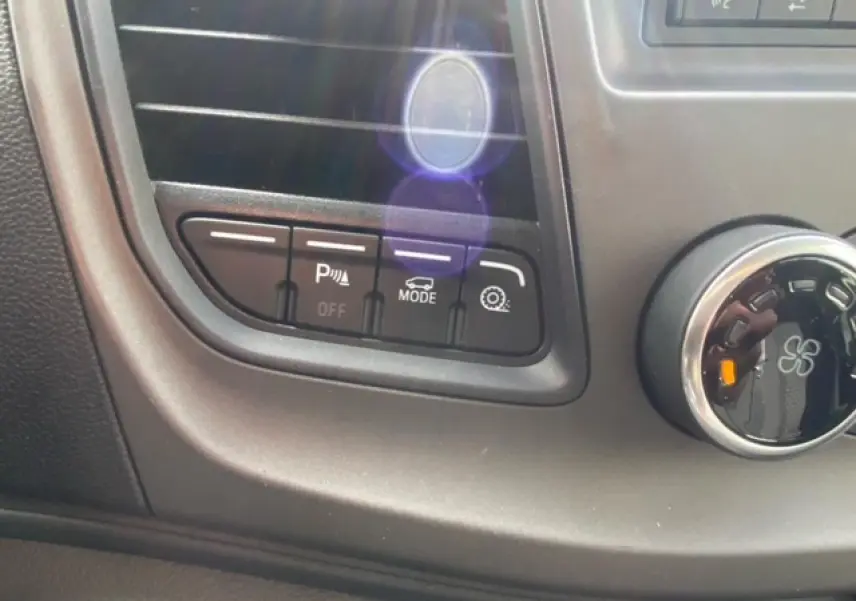 Gros plan sur les commandes de l'aide au stationnement et mode de conduite du Ford Transit Fourgon blanc 2023.