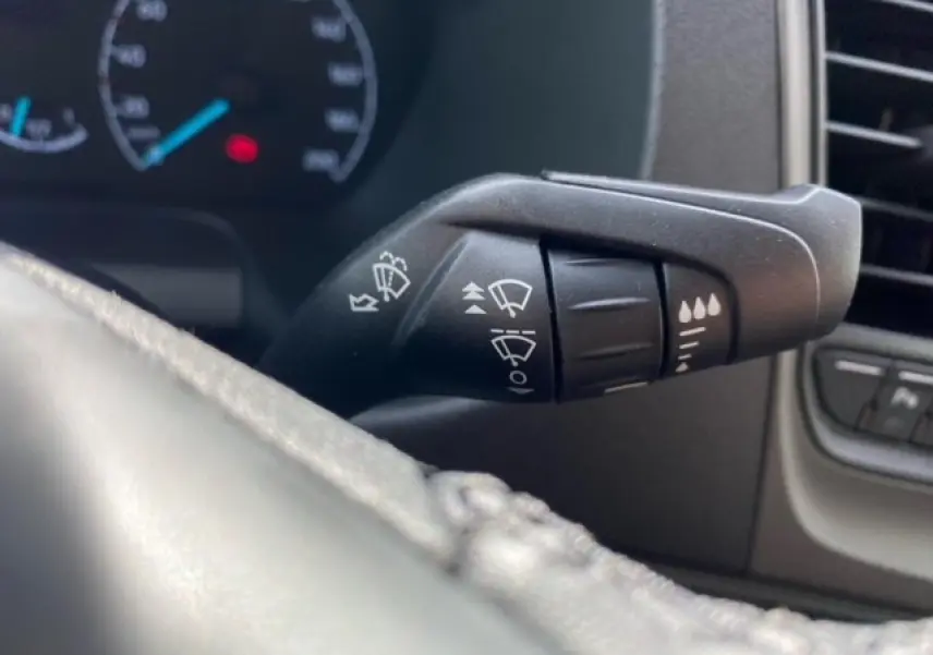 Gros plan sur la commande des essuie-glaces du Ford Transit Fourgon blanc 2023, intérieur tableau de bord.