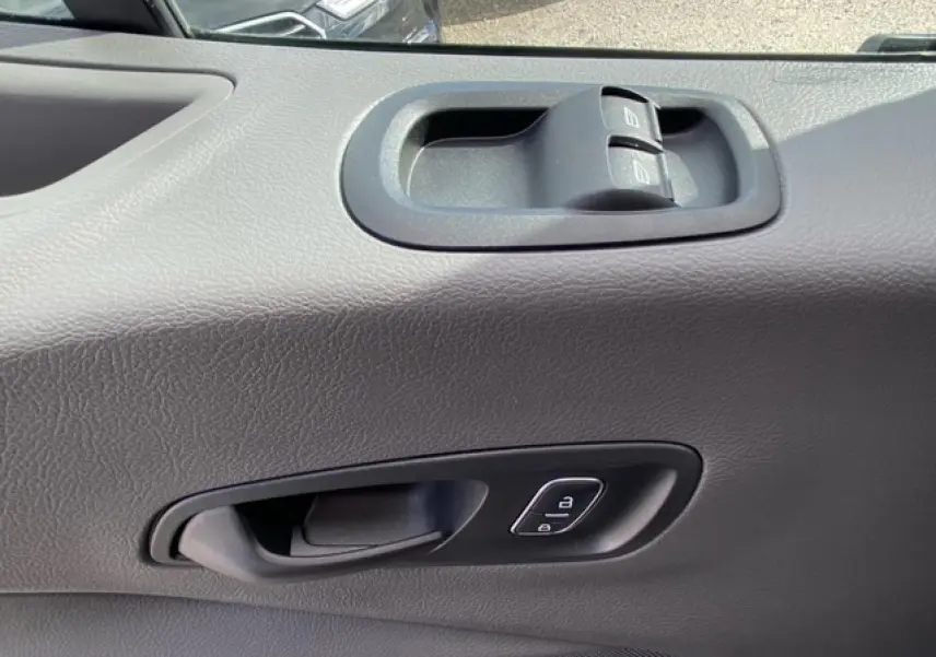 Gros plan sur la porte intérieure côté conducteur du Ford Transit Fourgon blanc, avec commandes de vitres et verrouillage.