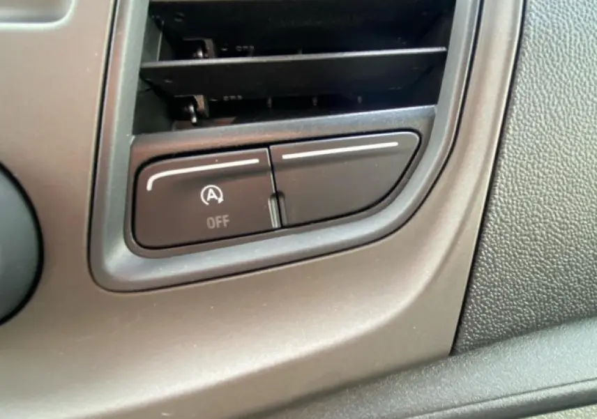 Bouton de commande noir de désactivation du système start-stop sur le tableau de bord du Ford Transit Fourgon blanc 2023.