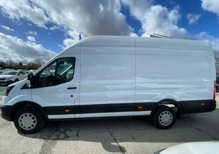 Fourgon Ford Transit blanc en vue profil côté gauche, avec porte latérale coulissante et jantes acier.