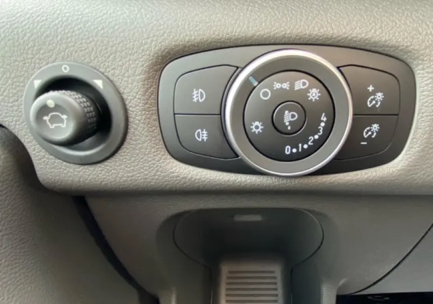 Gros plan sur les commandes d'éclairage et réglage du tableau de bord du Ford Transit Fourgon blanc 2023.