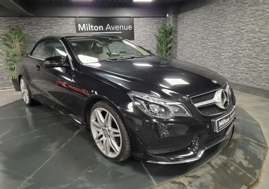Mercedes Classe E Cabriolet noir vue 3/4 avant droit en intérieur avec jantes alliage et capote fermée.