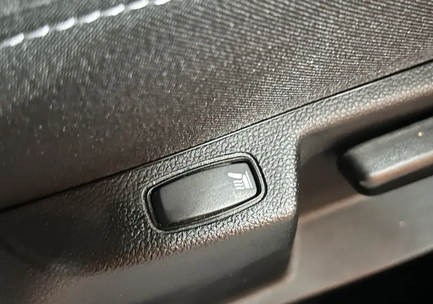Bouton de commande des sièges chauffants en gros plan dans l’habitacle du Dacia Duster 2024.