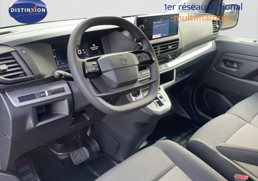 Vue intérieure côté conducteur du Citroën Jumpy 2025 avec tableau de bord moderne et sièges en tissu gris.