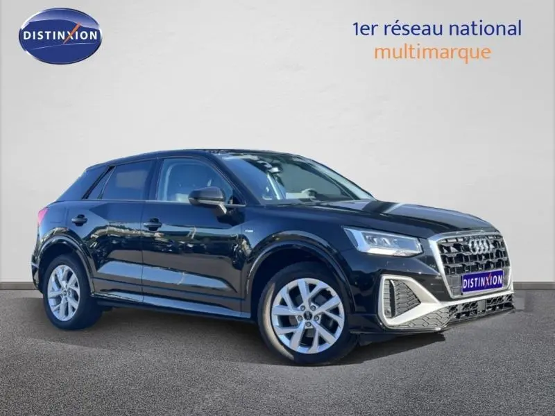 Audi Q2 noir vue 3/4 avant droit, avec jantes alu et calandre hexagonale distinctive.