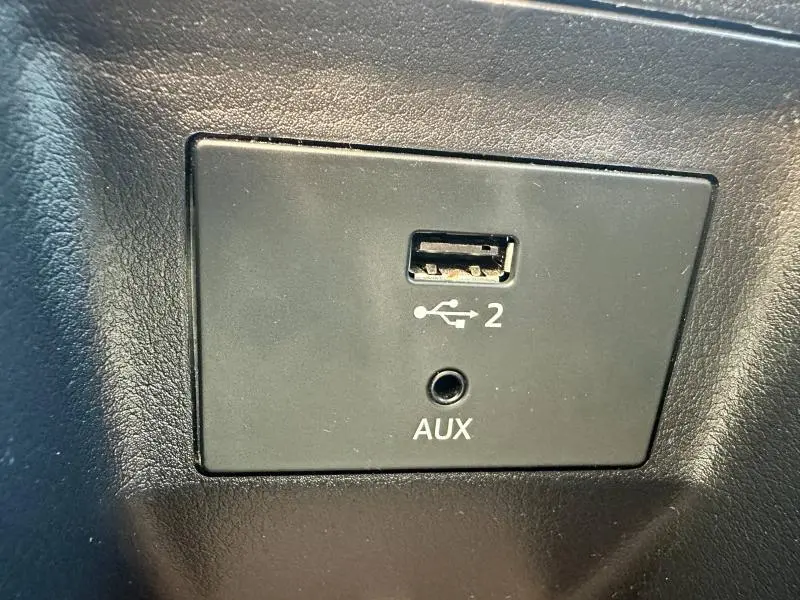 Gros plan sur la prise USB et entrée AUX noire dans l'habitacle de l'Audi Q2 blanc, version 35 TFSI S line.