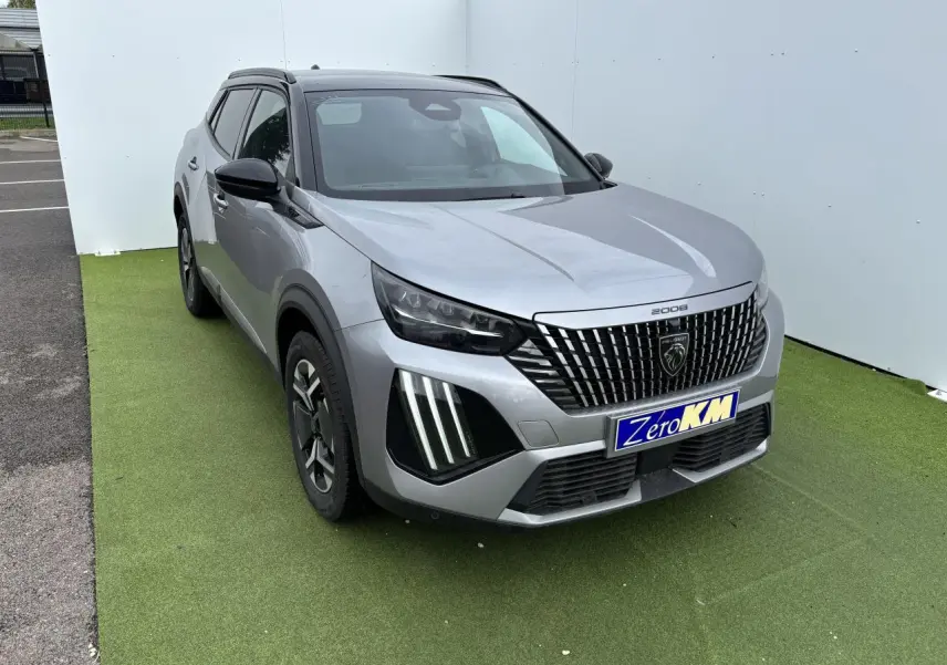 Peugeot 2008 gris Artense toit noir en 3/4 avant droit, calandre verticale et feux LED griffes visibles.