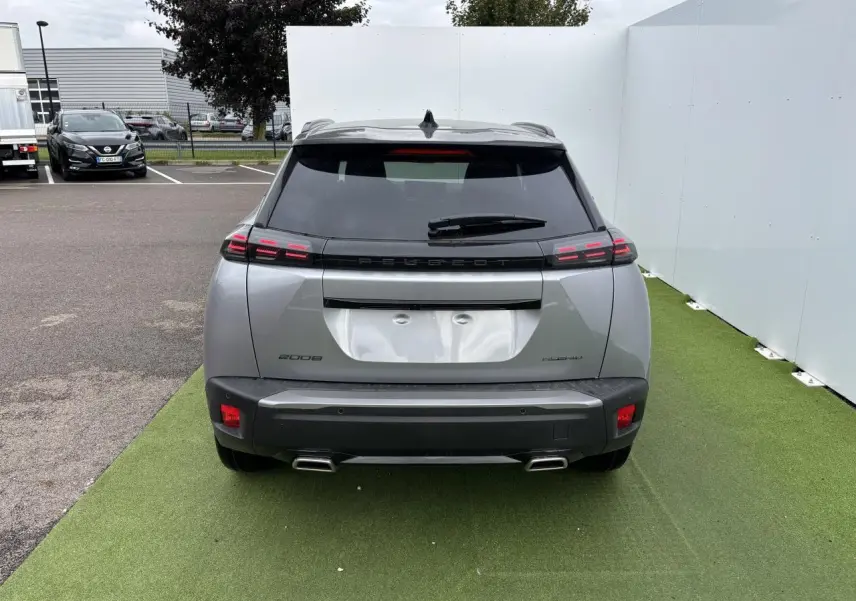 Vue arrière du Peugeot 2008 gris Artense avec toit noir, feux arrière LED à 3 griffes et double sortie d’échappement chromée.