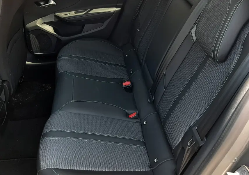 Vue latérale droite de la banquette arrière en tissu et cuir noir du Peugeot 408 Hybrid 2024 couleur gris selenium.