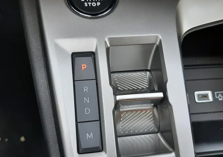 Détail de la console centrale du Peugeot 408 hybride 2024, avec bouton start/stop et commandes de boîte auto gris selenium.