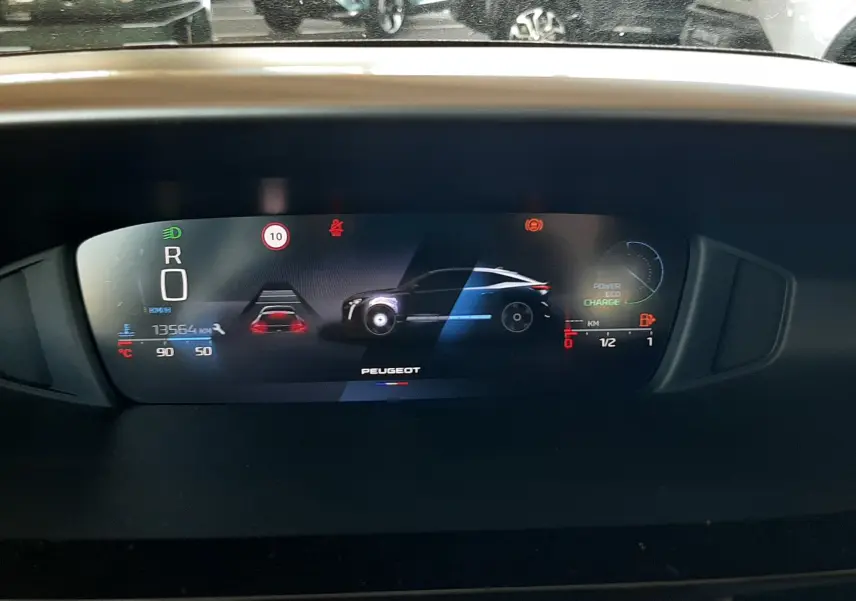 Affichage numérique du tableau de bord du Peugeot 408 Hybrid 145ch en mode stationnement, avec indicateurs de charge et vitesse.