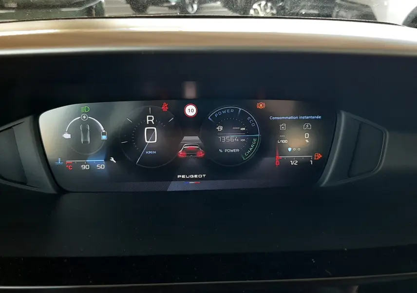 Vue rapprochée du tableau de bord numérique du Peugeot 408 Hybrid 145ch, affichant les informations de conduite et consommation.