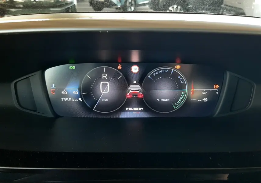 Tableau de bord numérique du Peugeot 408 Hybrid 145ch, affichage vitesse, énergie et alertes, vue frontale intérieure.