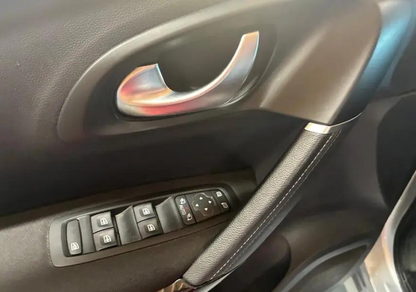 Gros plan sur la poignée intérieure et les commandes des vitres côté conducteur du Renault Kadjar gris 2020.