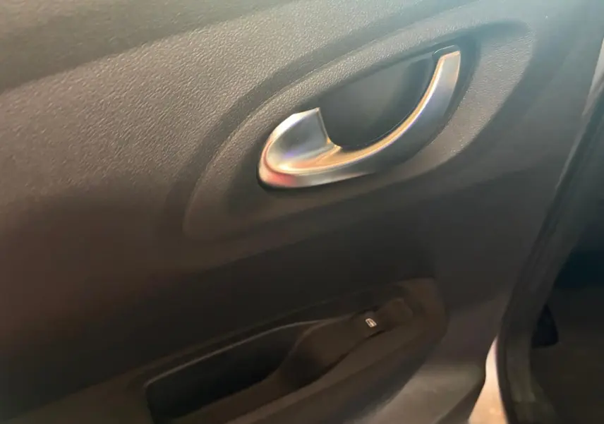 Poignée intérieure argentée et commande de lève-vitre sur la portière côté gauche du Renault Kadjar gris 2020.