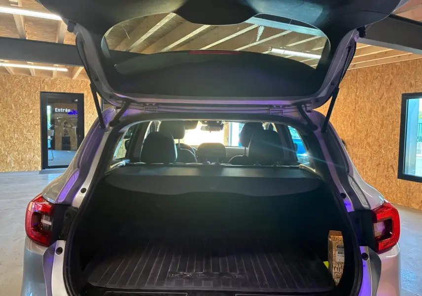 Vue arrière ouverte du Renault Kadjar gris 2020, coffre spacieux avec tapis de protection et intérieur noir visible.