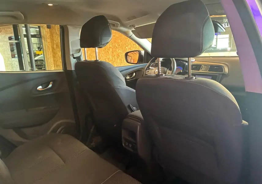 Vue intérieure arrière du Renault Kadjar gris 2020, montrant les sièges avant en tissu noir et la console centrale.