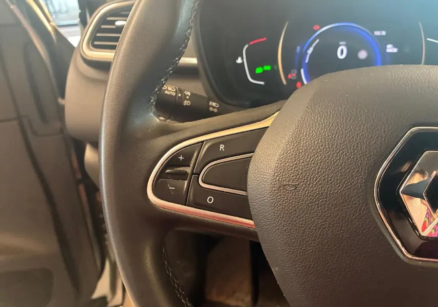 Gros plan sur le volant noir de Renault Kadjar 2020 avec commandes intégrées et tableau de bord numérique en arrière-plan.