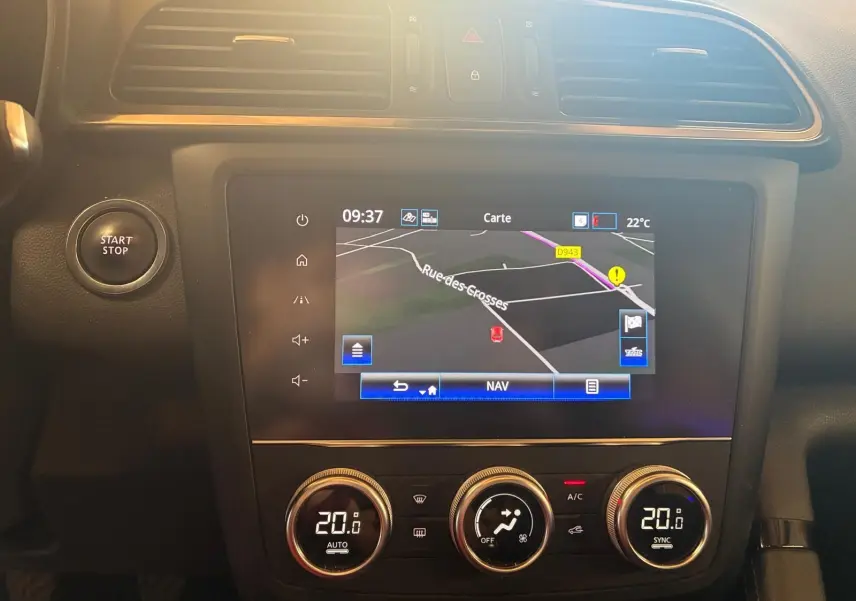 Vue rapprochée du tableau de bord du Renault Kadjar 2020 gris, avec écran GPS et commandes de climatisation digitales.