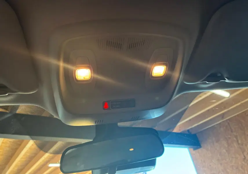 Vue intérieure en contre-plongée du plafonnier avec éclairage allumé et rétroviseur d’un Renault Kadjar gris 2020.