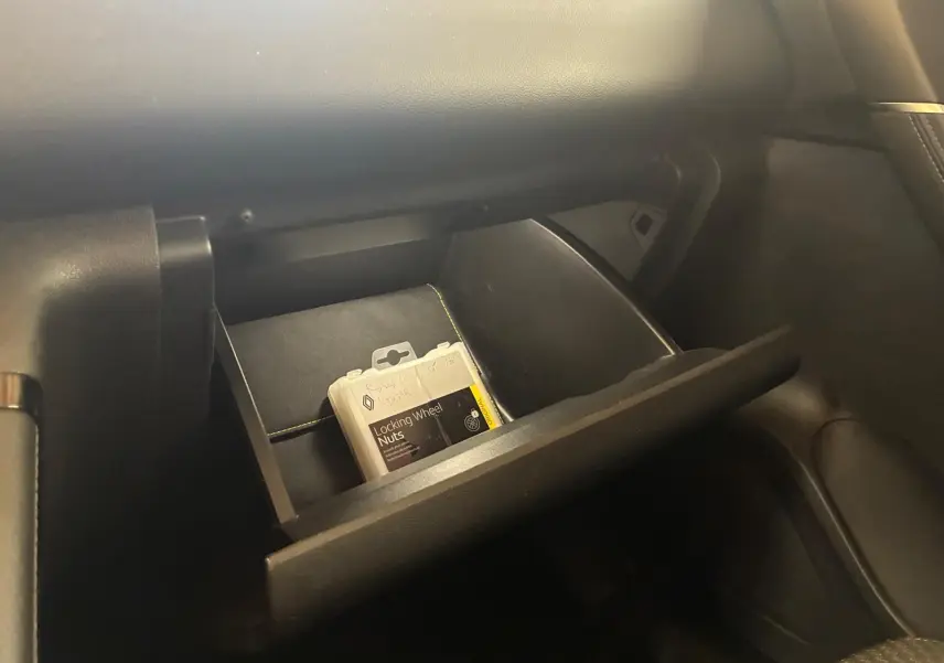 Gant de boîte à gants ouvert côté passager dans un Renault Kadjar gris 2020, avec notice de boulons antivol visible.