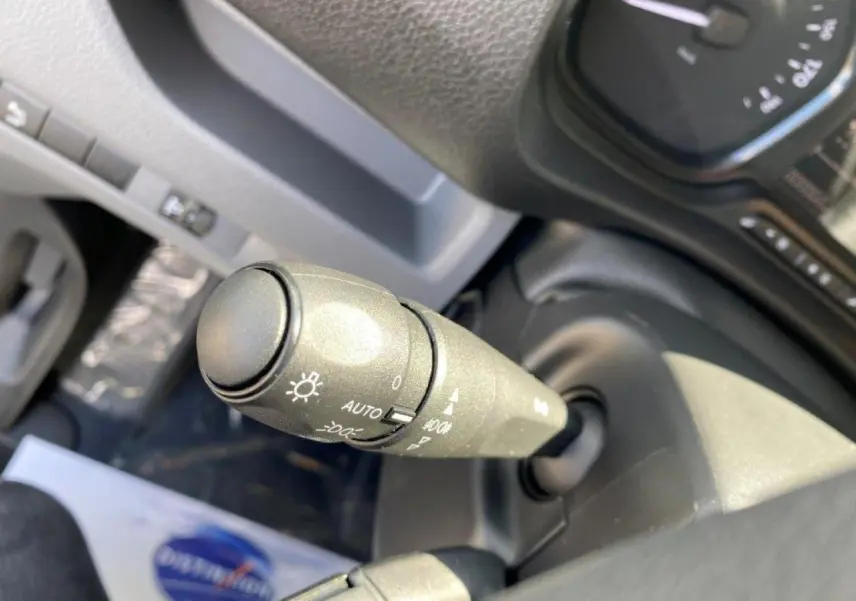 Gros plan sur la commande des phares du Peugeot Expert Fourgon blanc 2023, avec réglage automatique visible.