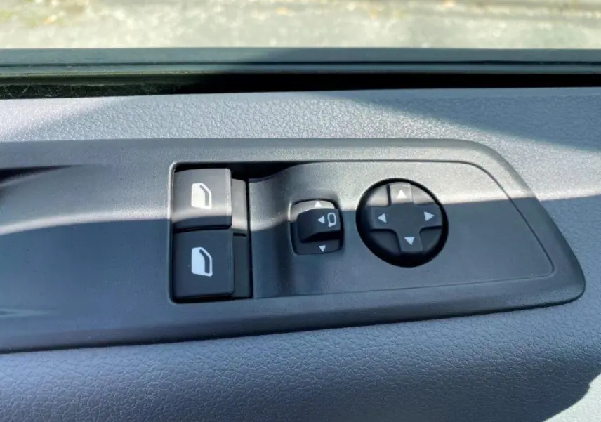 Gros plan sur les commandes de réglage des rétroviseurs et des vitres côté conducteur du Peugeot Expert Fourgon blanc 2023.